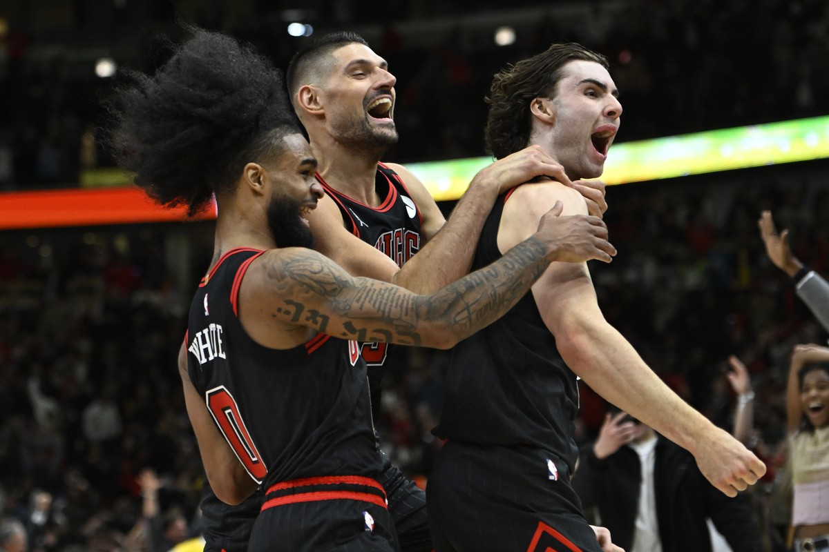 Chicago Bulls' Josh Giddey right, celebrates with teammates Nikola Vucevic center, and Coby White left, after making the winning basket against the Los Angeles Lakers in an NBA basketball game Th ...