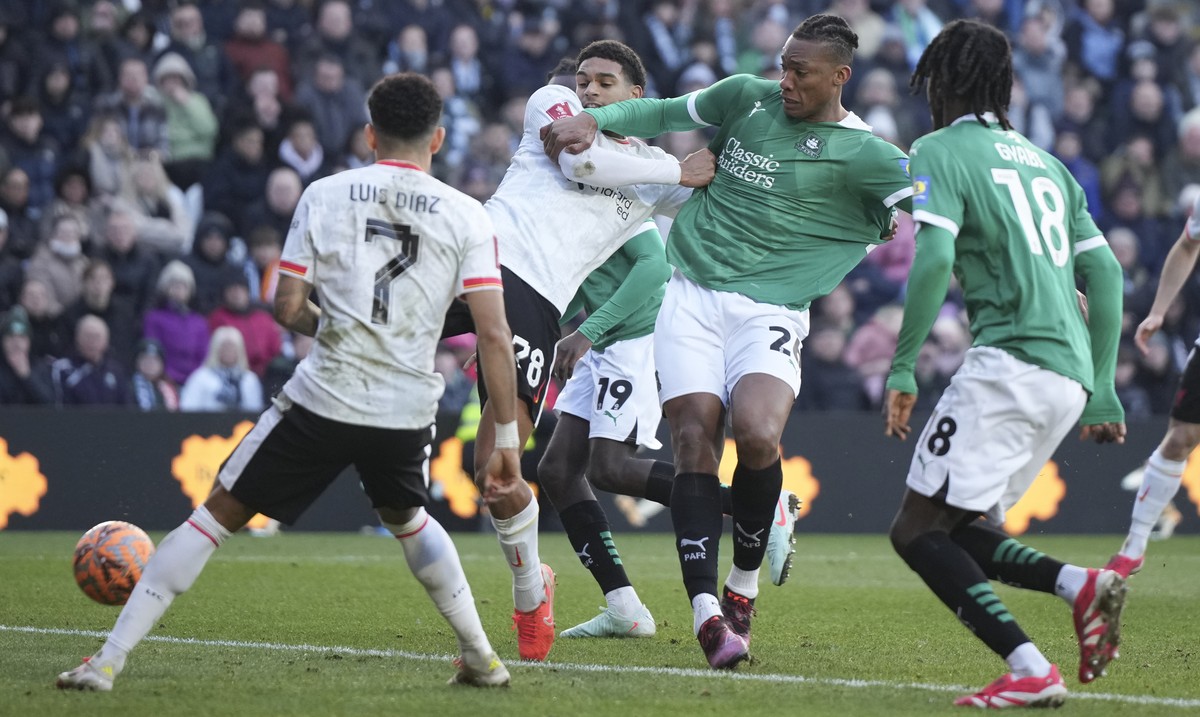 Liverpool's Jarell Quansah, left, challenges for the ball with Plymouth Argyle's Muhamed Tijani during the English FA Cup fourth round soccer match between Plymouth Argyle and Liverpool at H ...