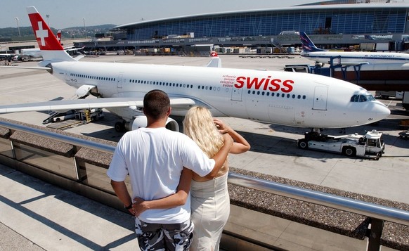 Ein Paar schaut sich am Montag, 11. August 2003, am Flughafen Unique bei Zuerich Kloten eine Maschine der Swiss an. (KEYSTONE/Steffen Schmidt)
