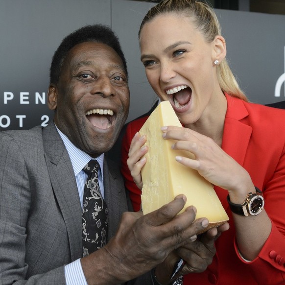 Brazilian soccer legend Pele, Edson Arantes do Nascimento, left, and Israeli model Bar Refaeli, right, eat a piece of Gruyere cheese during the inauguration ceremony of an extension of the manufacture ...