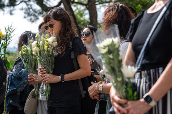 People offer flowers for the victims near the site of a deadly Wednesday fire at Wang Fuk Court, a residential estate in the Tai Po district of Hong Kong&#039;s New Territories on Monday, Dec. 1, 2025 ...