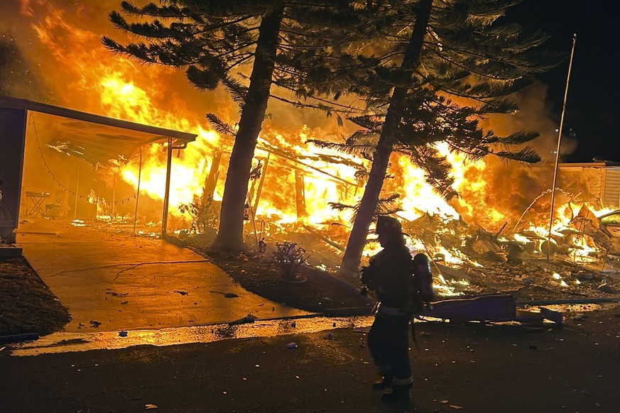 Firefighters respond to a fire after a small plane crashed on Thursday evening, February 1, 2024.  The pilot and two people on the ground were killed when the single-engine Beechcraft Bonanza V35 crashed into the…