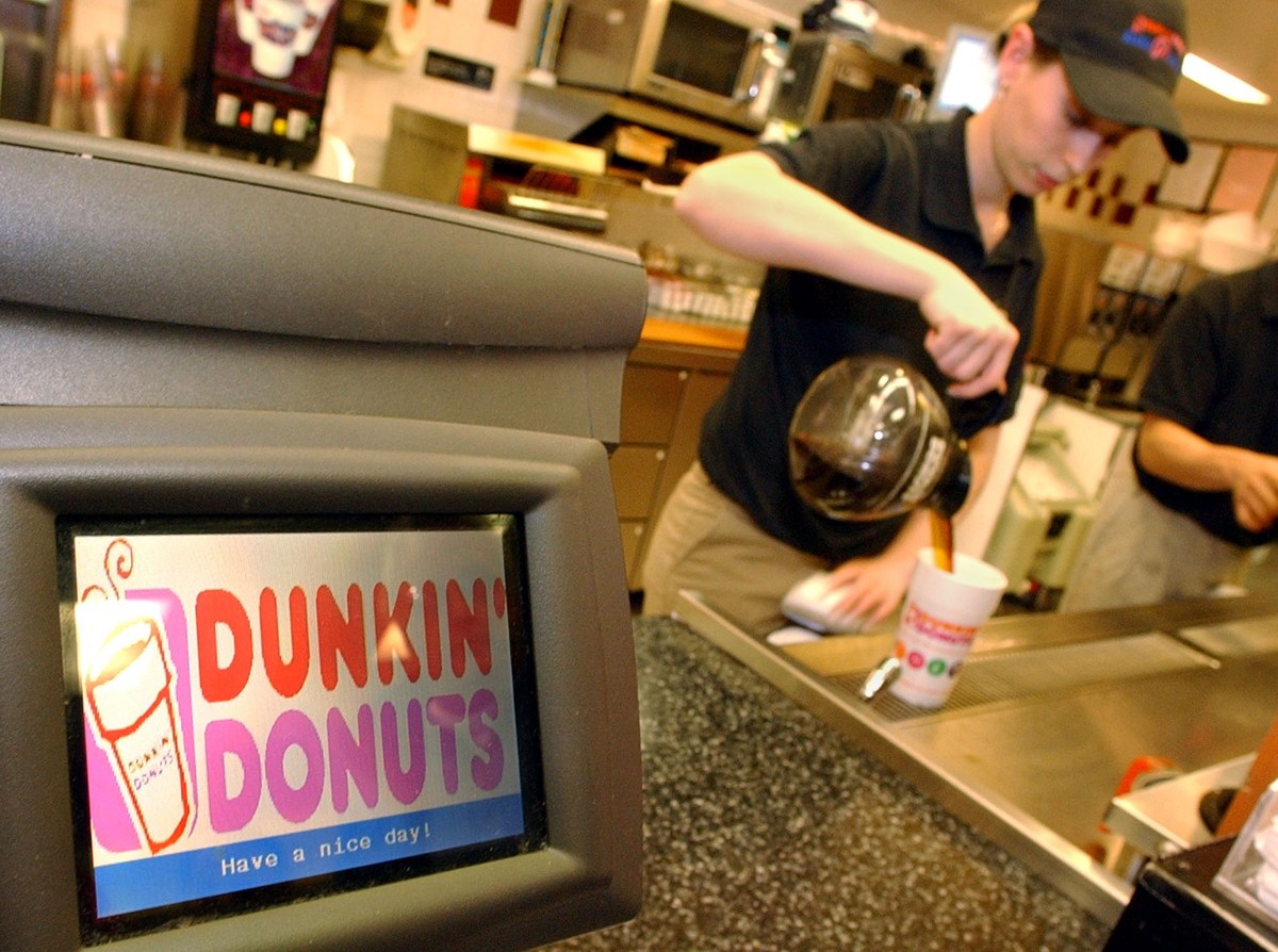 Dunkin' Donuts employee Sandra Manoel pours coffee for a customer in Cambridge, Mass. in this Dec. 8, 2005 photo. Three private equity firms have agreed to buy Dunkin' Donuts and two other r ...