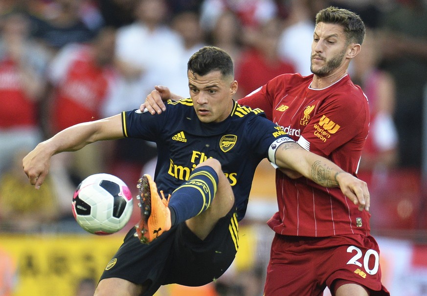 epa07791365 Liverpool&#039;s Adam Lallana (R) in action against Arsenal&#039;s Granit Xhaka (L) during the English Premier League soccer match between Liverpool FC and Arsenal FC at Anfield in Liverpo ...