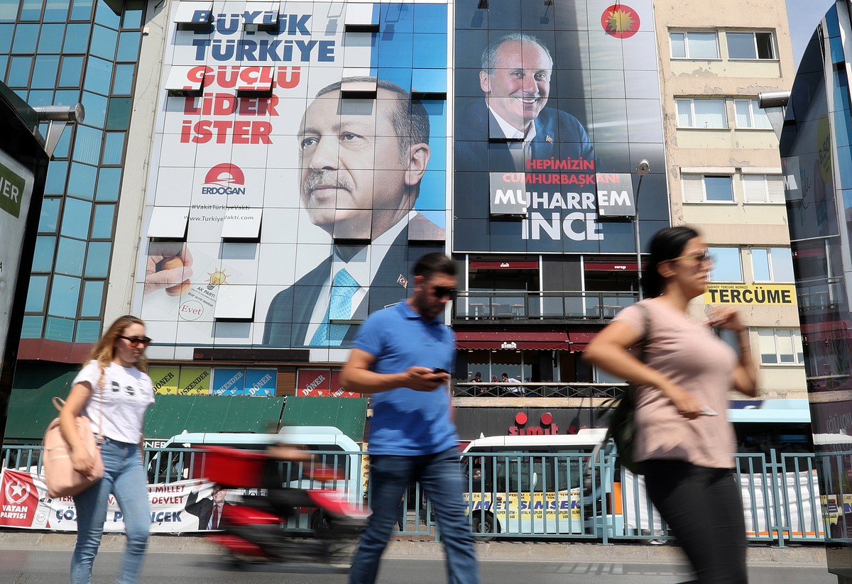 epa06788906 People walk under a huge picture of Turkish President Recep Tayyip Erdogan (L) and Muharrem Ince (R), Presidential candidate of Turkey's main opposition Republican People's Party ...