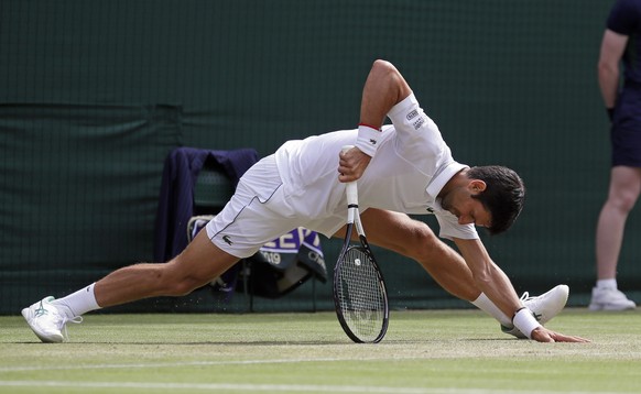 Serbia's Novak Djokovic gets to his feet after returning to Poland's Hubert Hurakacz in a Men's singles match during day five of the Wimbledon Tennis Championships in London, Friday, Ju ...