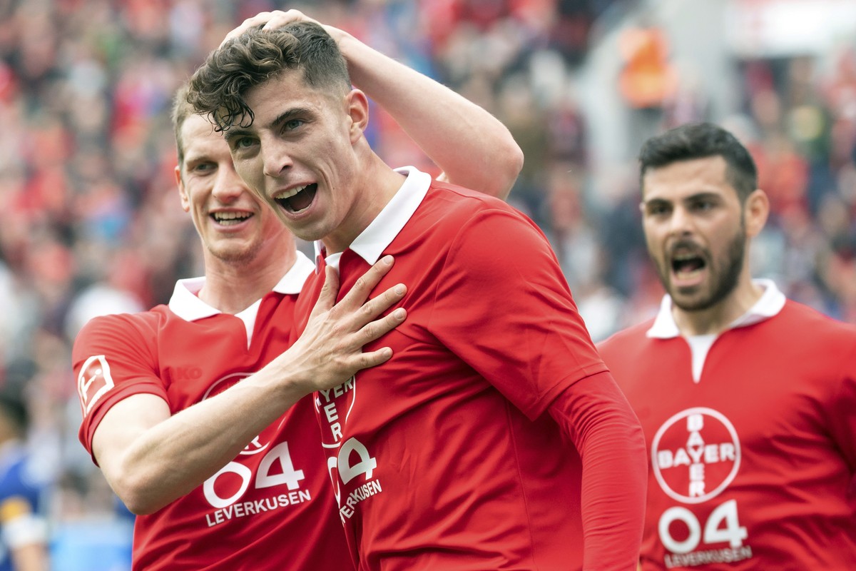 Leverkusen's Kai Havertz, center, celebrates his side opening goal with team mates Lars Bender, left, and Kevin Holland, right, during the German Bundesliga soccer match between Bayer Leverkusen  ...