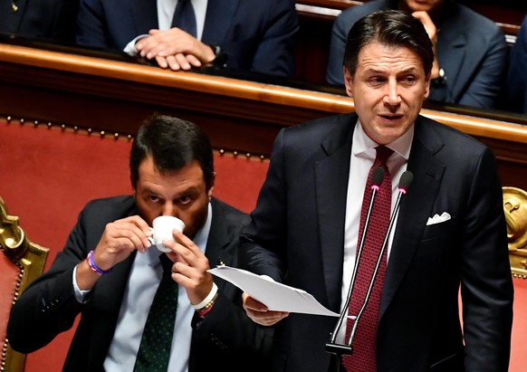 epa07782273 Italian Prime Minister Giuseppe Conte (R) is flanked by Deputy Prime Ministers Matteo Salvini (L) as he addresses the Senate in Rome, Italy, 20 August 2019. Conte in his address to the sen ...