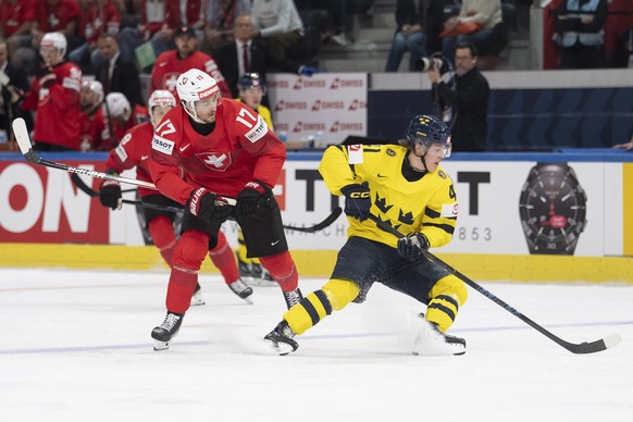 epa13001142 Switzerland's Ken Jager (L) in action against Sweden's Ivar Stenberg during the 2026 IIHF Men's Ice Hockey World Championship Quarterfinal game between Switzerland and Swede ...