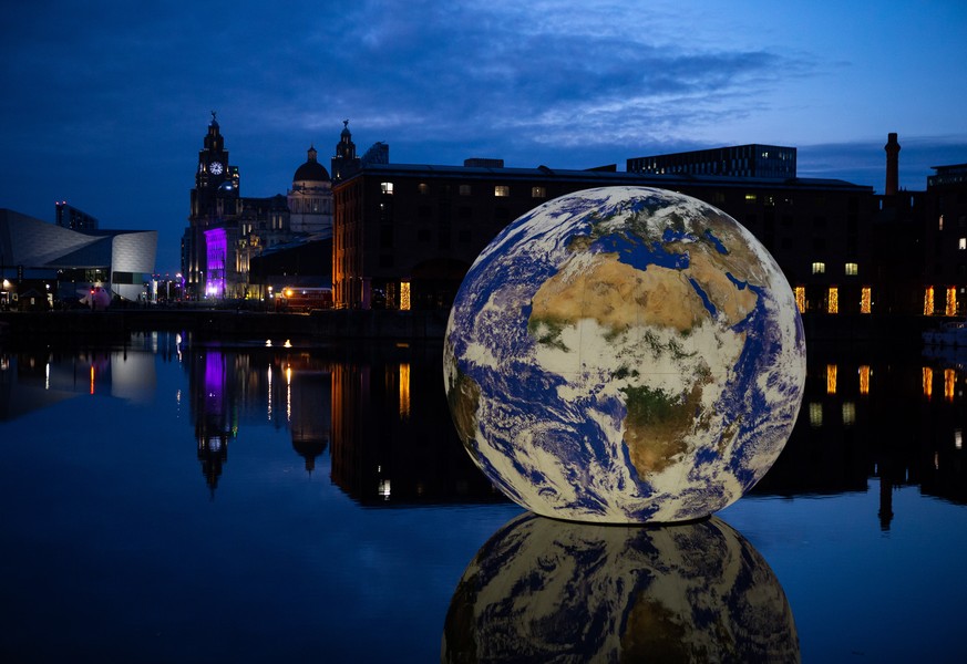 epaselect epa10597586 The installation ?Floating Earth? by artist Luke Jerram at the Royal Albert Dock in Liverpool, Britain, 28 April 2023. The 10-metre installation, created using NASA imagery and f ...
