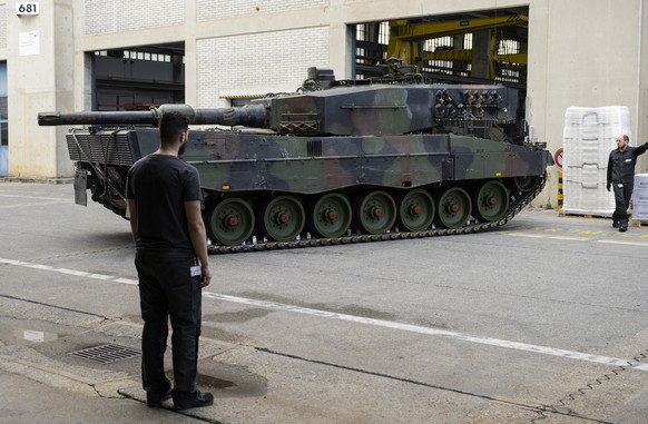 A Leopard 2 tank being maneuvered into a RUAG maintenance hangar in Thun on Monday 20 March 2023.  (KEYSTONE/Peter Schneider)