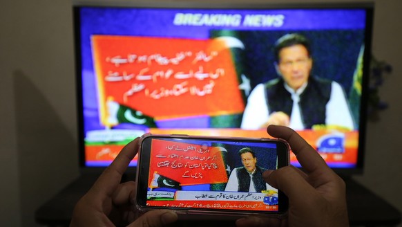 epa09879065 People watch a televised speech by the Pakistan Prime Minister Imran Khan, a day after the country&#039;s top court set aside the government&#039;s move to block a no-trust vote and subseq ...
