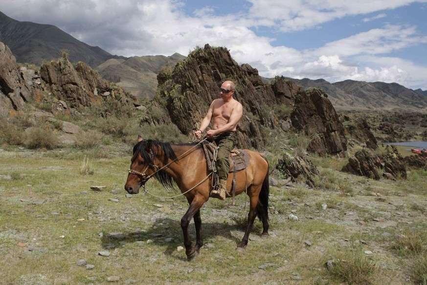 In this photo taken on Monday, Aug. 3, 2009, Russian Prime Minister Vladimir Putin seen riding a horse in the mountains of the Siberian Tyva region (also referred to as Tuva), Russia, during his short ...