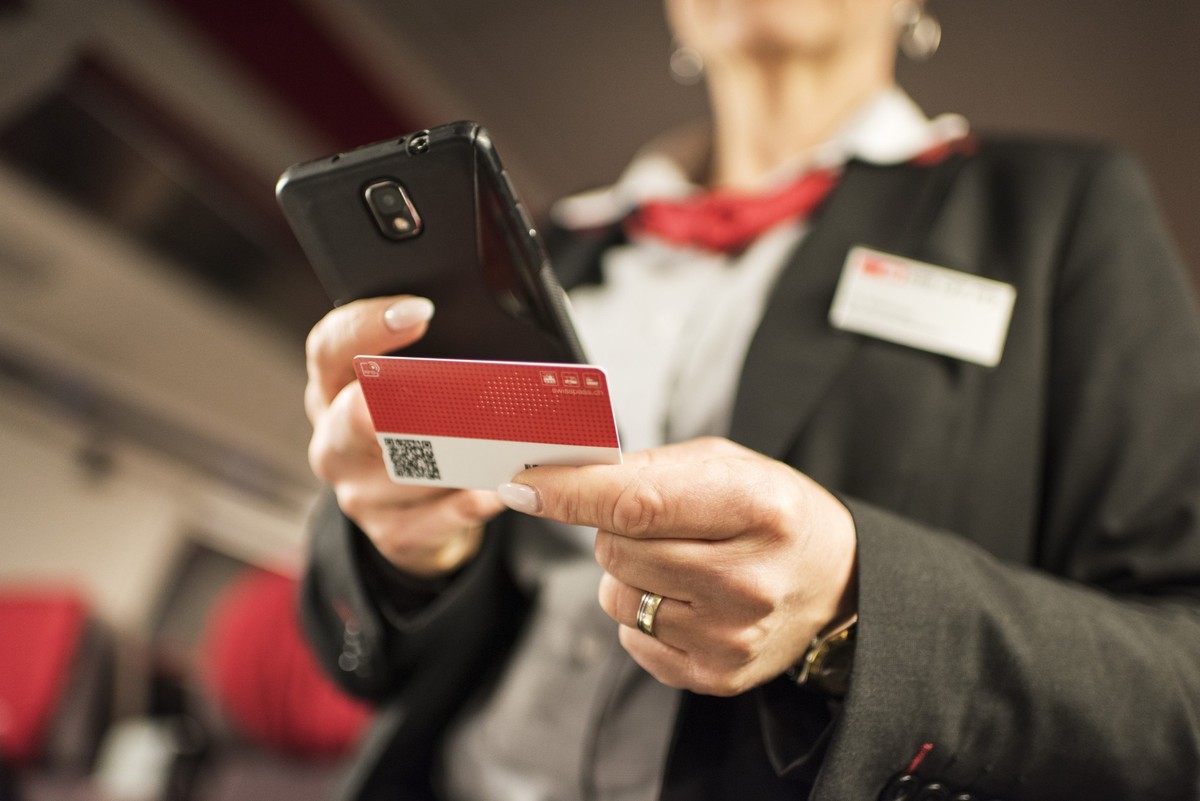 A train conductor of the Swiss Federal Railways checks a passenger's Swiss Pass on a train travelling from Zurich to Lucerne, Switzerland, on March 20, 2017. (KEYSTONE/Christian Beutler)