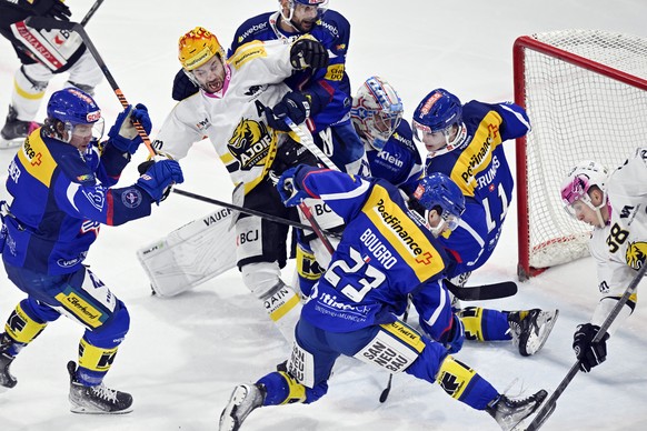 Ajoies Michael Devos Philip, links, und Guillaume Asselin, rechts, bedraengen Klotens Abwehr beim Eishockey-Qualifikationsspiel der National League zwischen dem EHC Kloten und dem HC Ajoie in der Stim ...