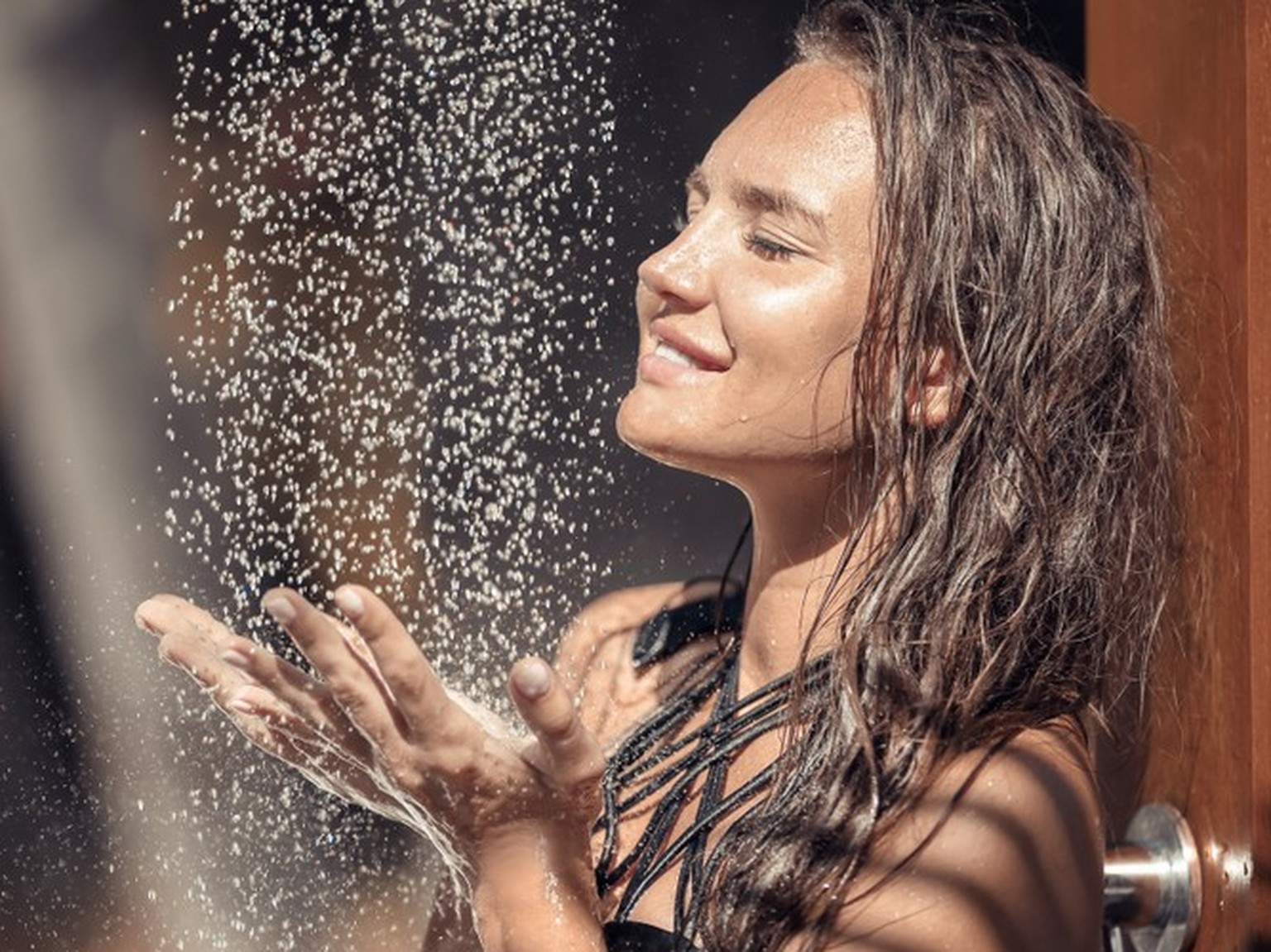 Frau duscht am Strand