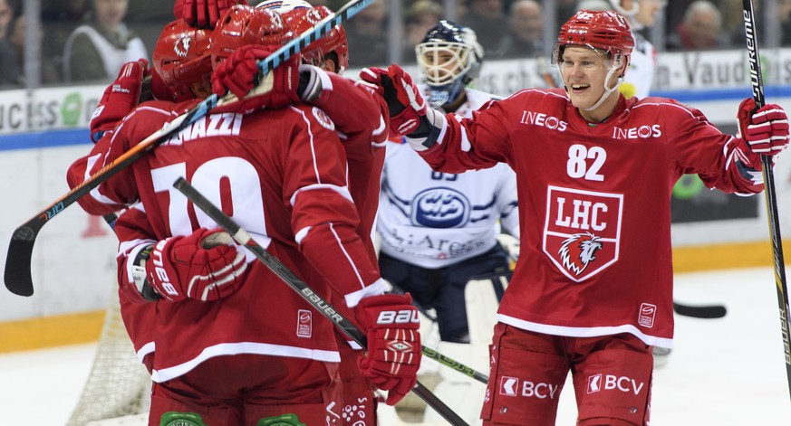 L&#039;attaquant lausannois Harri Pesonen, droite, celebre avec ses coequipiers le 2eme but devant le gardien tessinois Sandro Zurkirchen, centre, lors du match du championnat suisse de hockey sur gla ...