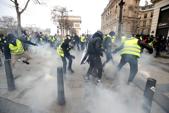 epa07216304 Some Yellow Vests (Gilets jaunes) protesters clash with police forces during a demonstration near the Champs Elysees in Paris, France, 08 December 2018. Police in Paris is preparing for another weekend of protests of the so-called 'gilets jaunes' (yellow vests) protest movement. Recent demonstrations of the movement, which reportedly has no political affiliation, had turned violent and caused authorities to close some landmark sites in Paris this weekend.  EPA/IAN LANGSDON