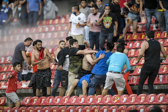 Fans clash during a Mexican soccer league match between the host Queretaro and Atlas from Guadalajara, at the Corregidora stadium, in Queretaro, Mexico, Saturday, March 5, 2022. Multiple people were i ...