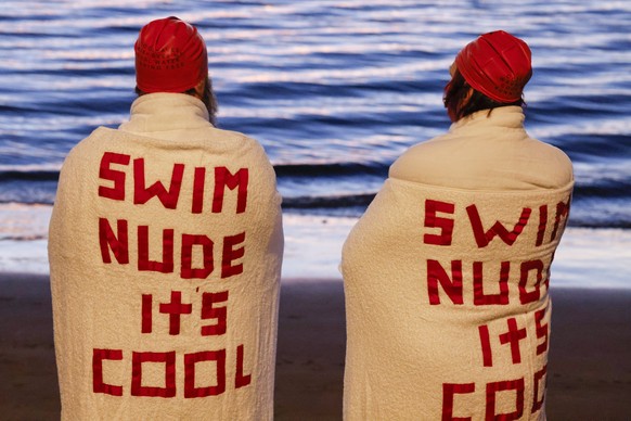 epa10026932 Swimmers gather before the annual nude winter solstice swim during Hobart&#039;s Dark Mofo festival at Long Beach in Sandy Bay, Tasmania, Australia, 22 June 2022. EPA/ROB BLAKERS AUSTRALIA ...
