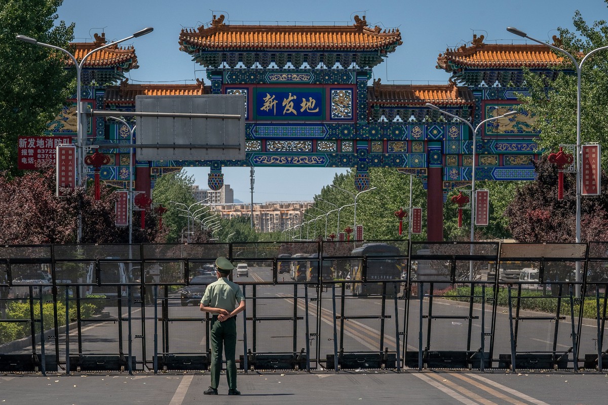 epa08484450 A paramilitary police officer stands guard at the entrance to the closed Xinfadi market, in Fengtai district, Beijing, China, 14 June 2020. One of Beijing's largest markets, Xinfadi i ...