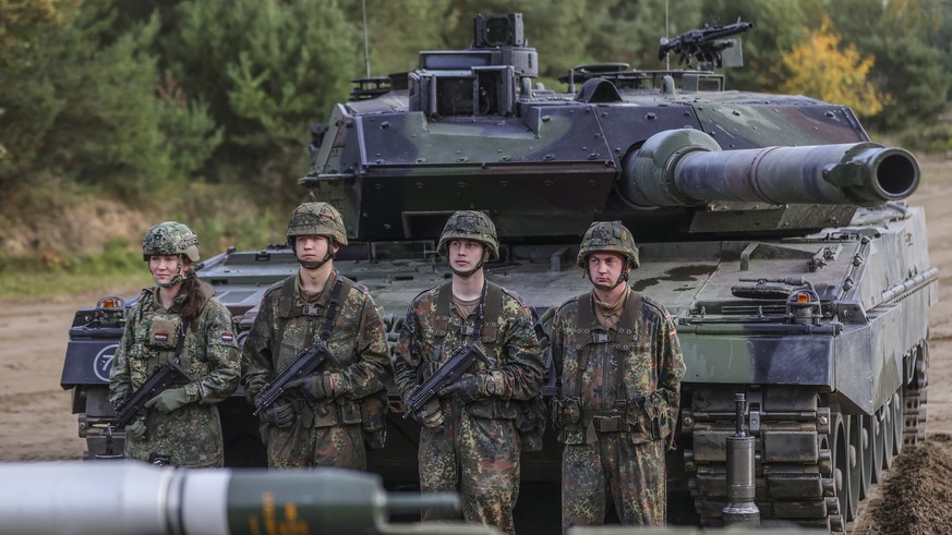 epa10248366 Soldiers stand next to a Leopard 2 battle tank during a media presentation for the annual Land Operation Exercise of the German armed forces Bundeswehr in Bergen, northern Germany, 17 Octo ...