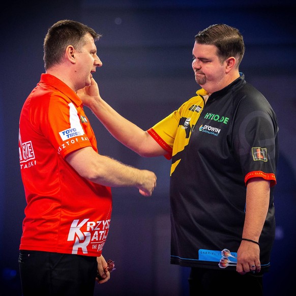 William Hill World Darts Championship 29/12/2020. Gabriel Clemens Germany congratulates Krzysztof Ratajski Poland during Round 4 of the William Hill World Darts Championship at Alexandra Palace, Londo ...