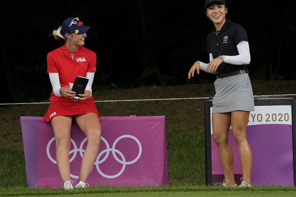 Nelly Korda, of the United States, left, and Lydia Ko, of New Zealand, speak as they wait on the 14th tee box during the final round of the women&#039;s golf event at the 2020 Summer Olympics, Saturda ...