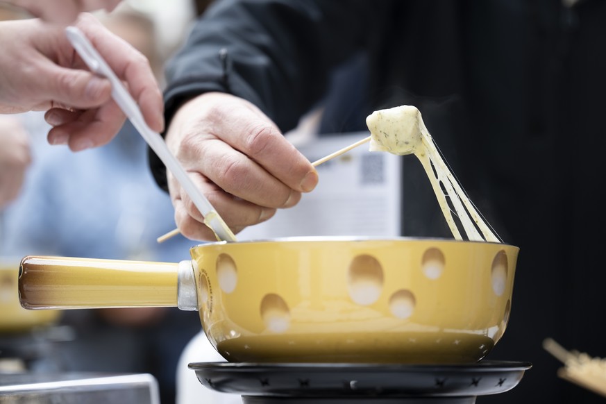 Un visiteur goute une fondue lors du 1er Suisse fondue festival, ce jeudi 17 novembre 2022, sur la place Georges-Python, a Fribourg. Cette premier edition qui se deroule du 17 au 20 novembre, met la f ...