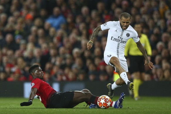 Manchester United&#039;s Paul Pogba, left, slides into tackle Paris Saint Germain&#039;s Dani Alves during the Champions League round of 16 soccer match between Manchester United and Paris Saint Germa ...