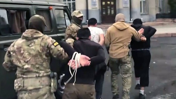 Russia Terrorist Detention 8254878 08/18/2022 In this handout video recording released by the Russian Federal Security Service FSB, FSB agents escort detained members of Katiba al-Tawhid wal-Jihad terro...