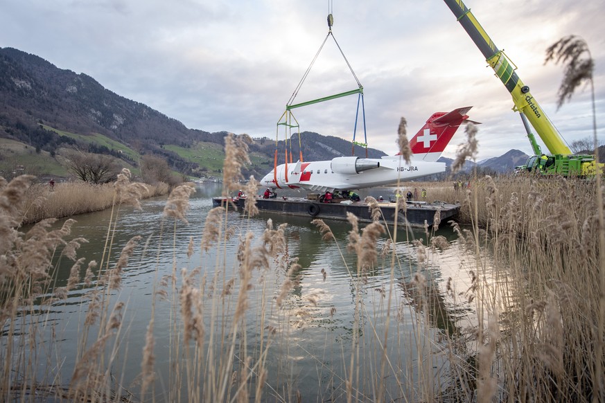 Der Rega Ambulanzjet CL-604, HB-JRA wird am Freitag, 8. Maerz 2019 auf ein Ponton hehievt, dies anlaesslich des Transports vom Flugplatz Alpnach ber den Vierwaldstaettersee nach Luzern ins Verkehrsha ...