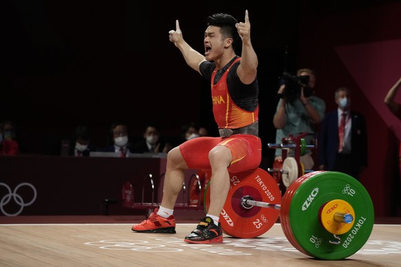 Shi Zhiyong of China celebrates after winning the gold medal and sets a new Olympic record in the men&#039;s 73kg weightlifting event, at the 2020 Summer Olympics, Wednesday, July 28, 2021, in Tokyo,  ...