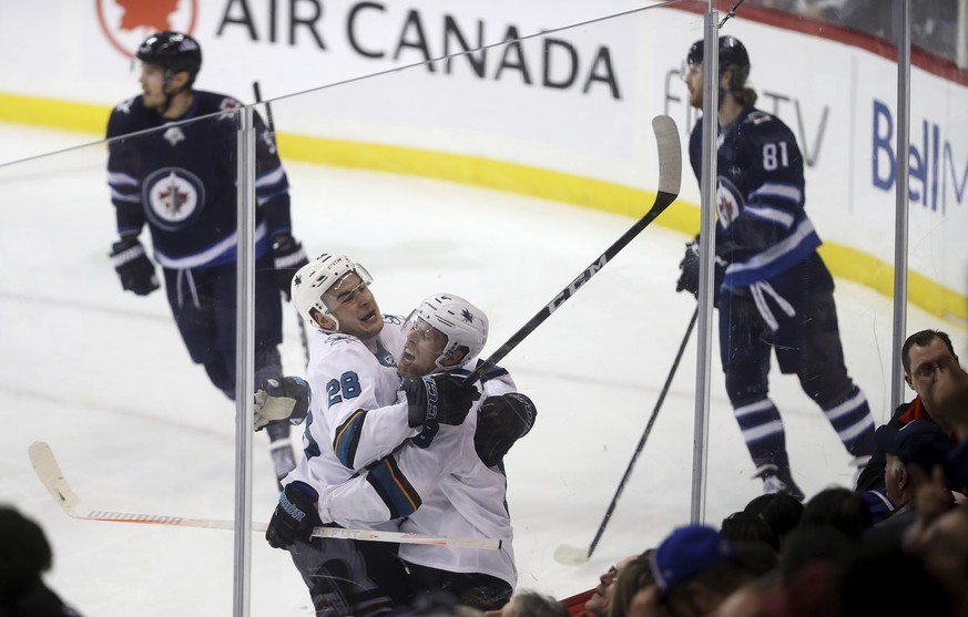 San Jose Sharks&#039; Timo Meier (28) and Joe Pavelski (8) celebrate after Pavelski scored with just seconds left to beat the Winnipeg Jets during the third period of an NHL hockey game in Winnipeg, M ...