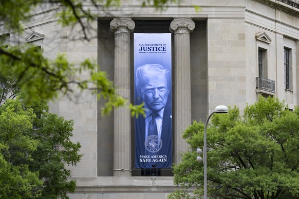 epa12922677 A banner depicting US President Trump hangs on the United States Department of Justice where acting Attorney General Todd Blanche and recently confirmed Alcohol Tobacco and Firearms (ATF)  ...