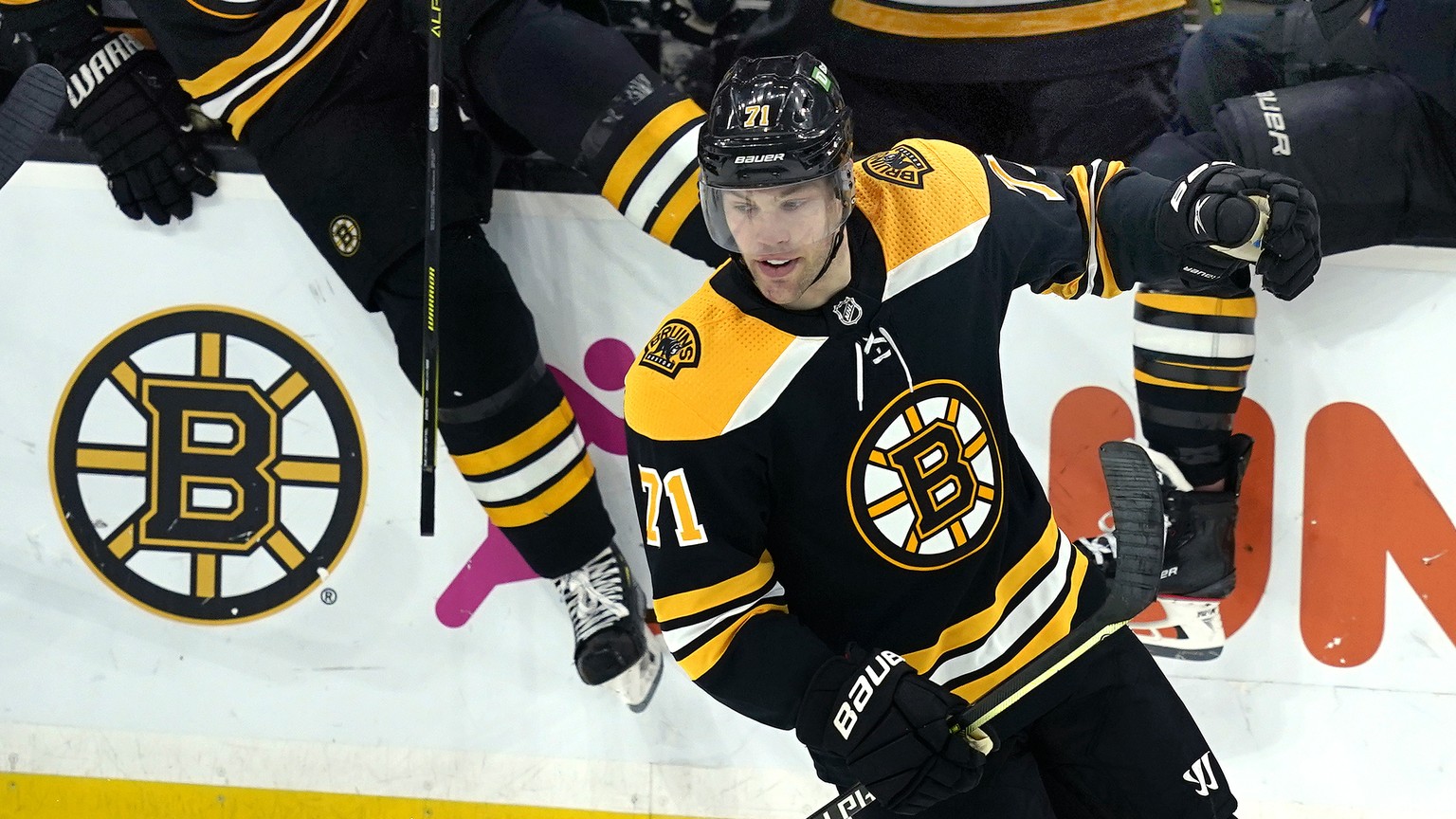 Boston Bruins players step over the bench to join Bruins left wing Taylor Hall (71) on the ice to celebrate his winning goal in the overtime period of an NHL hockey game against the New York Islanders ...
