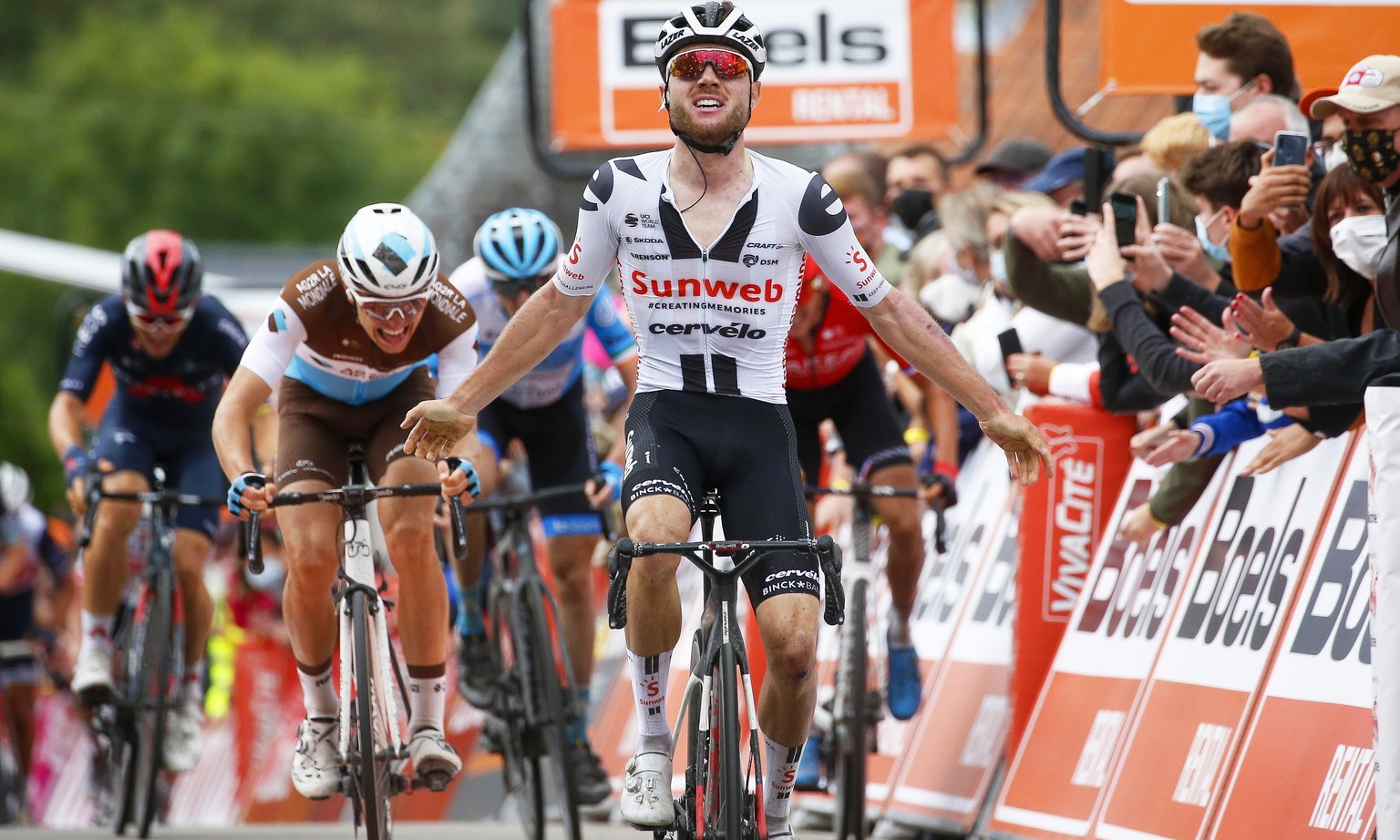 epa08708899 Swiss rider Marc Hirschi (C) of Team Sunweb celebrates while crossing the finish line to win the 84th edition of the Fleche Wallonne one day cycling race over 202km from Herve to Huy, Belg ...