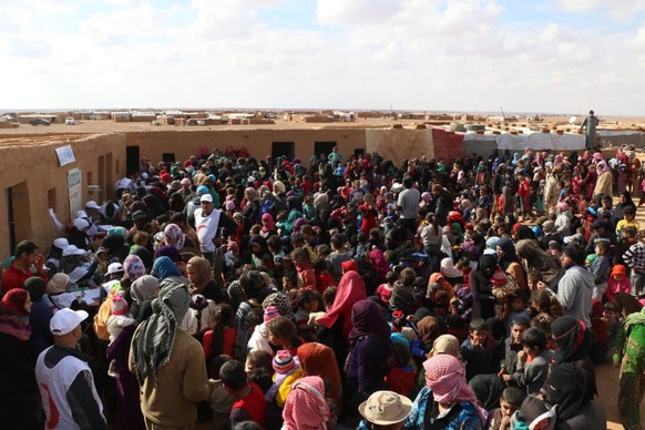 epa07142941 A handout photo made available by Syrian Arabic Red Crescent (SARC) showing displaced Syrians gather as SARC personnel conduct a vaccination campaign to immunize children against measles,  ...