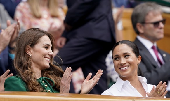 epa07714374 Catherine (L), the Duchess of Cambridge and Meghan Markle, the Duchess of Sussex in the Royal Box on Centre Court during the Wimbledon Championships at the All England Lawn Tennis Club, in ...