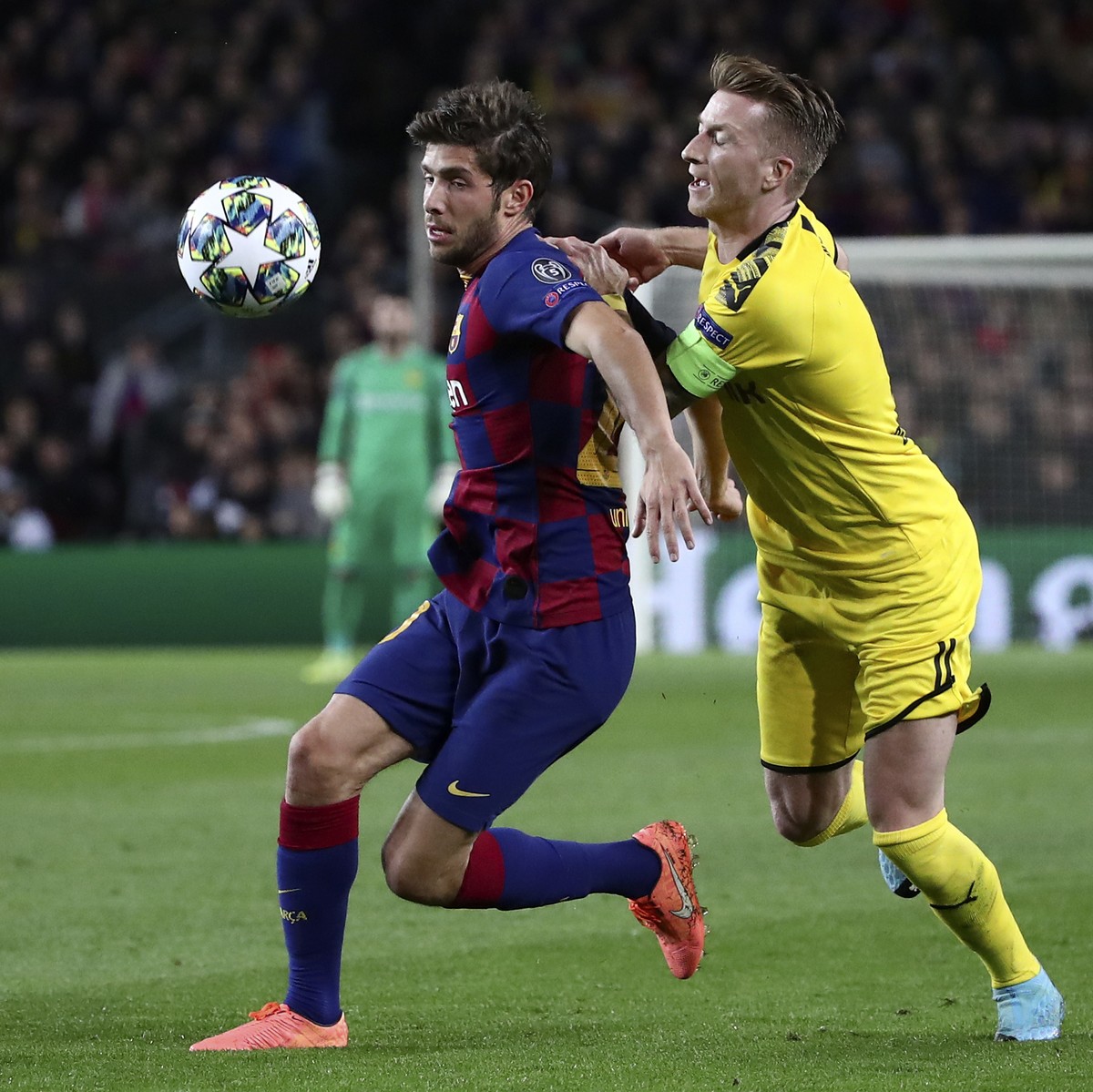 Barcelona's Sergi Roberto vies for the ball with Dortmund's Marco Reus, right, during a Champions League group F soccer match between Barcelona and Borussia Dortmund at the Camp Nou stadium  ...