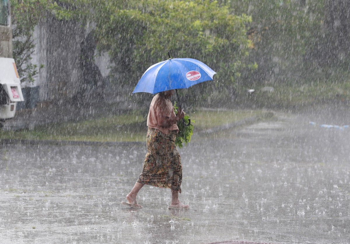 epa13283167 A woman walks during rainfall in Yangon, Myanmar, 05 October 2026. Myanmar faces severe risks of extreme weather, abnormal rainfall, high temperatures, and water shortages as a Super El Ni ...