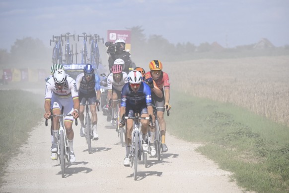 Netherlands&#039; Mathieu van der Poel, left, Denmark Jakob Fuglsang, second left, France&#039;s David Gaudu, second right in blue, and Norway&#039;s Tiller Rasmus, right, ride on a gravel road during ...