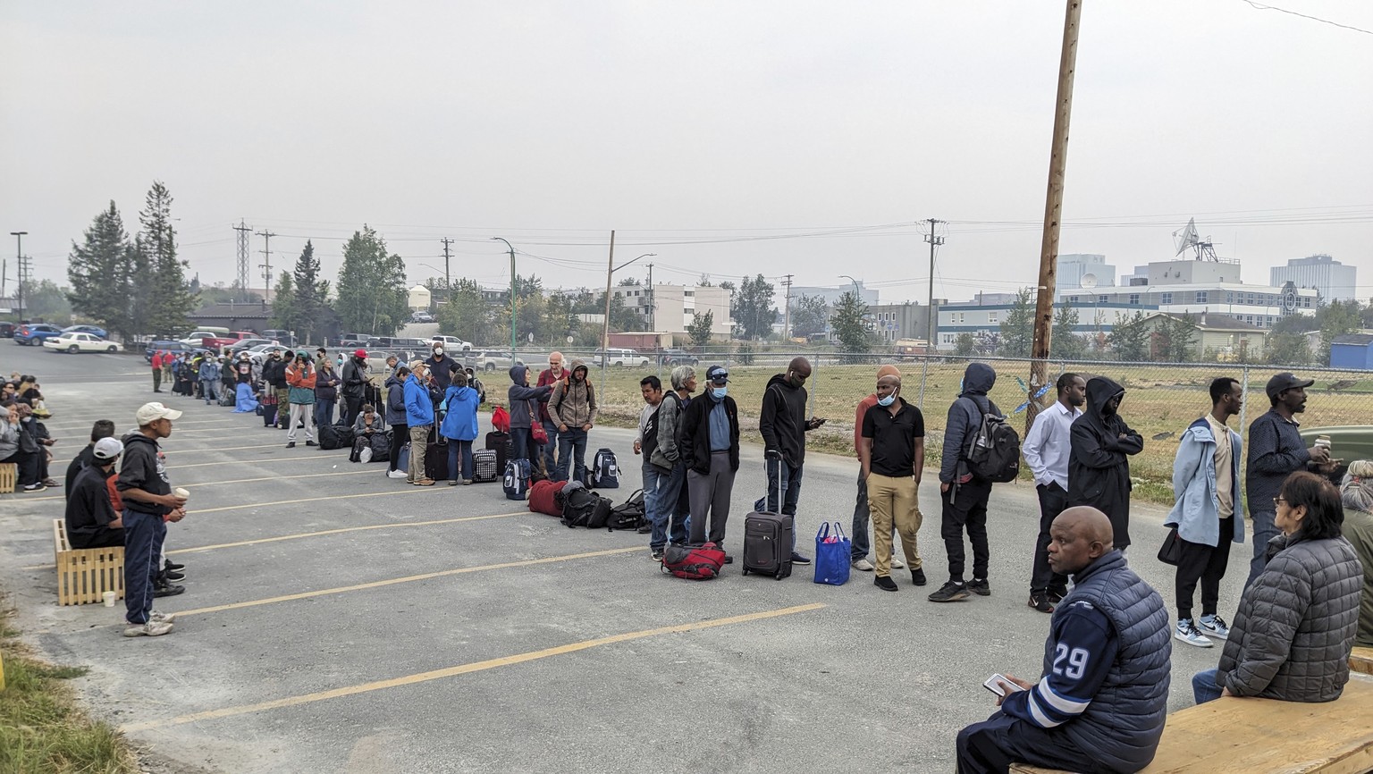 People without vehicles lineup to register for a flight to Calgary, Alberta in Yellowknife on Thursday, Aug. 17, 2023. Prime Minister Justin Trudeau is expected to convene an urgent meeting with minis ...