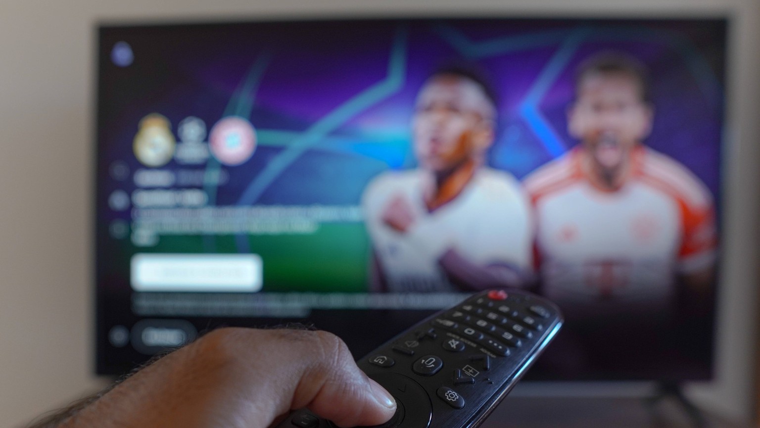May 6, 2024, Brazil: In this photo illustration, a hand holding a TV remote control in front of the TV screen with the broadcast call of the game between Real Madrid and FC Bayern M