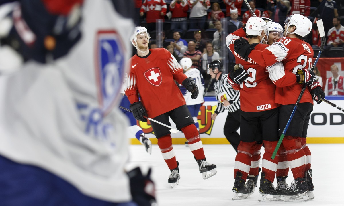 Switzerland's forward Enzo Corvi, 2nd right, celebrates his goal with teammates forward Nino Niederreiter #22 and forward Timo Meier, right, past Switzerland's defender Mirco Mueller, left,  ...