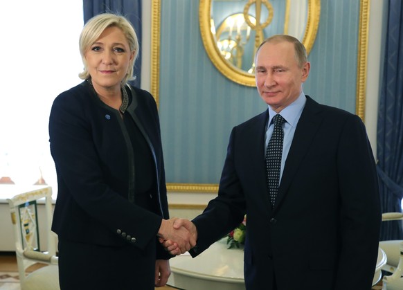 FILE - Russian President Vladimir Putin, right, shakes hands with French far-right presidential candidate Marine Le Pen, in the Kremlin in Moscow, Russia, Friday, March 24, 2017. Jailed Russian opposi ...