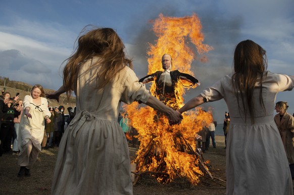 Demonstrators dance around a burning an effigy of the Russian President Vladimir Putin during an anti-war action in Tbilisi, Georgia, Sunday, March 27, 2022. (AP Photo)