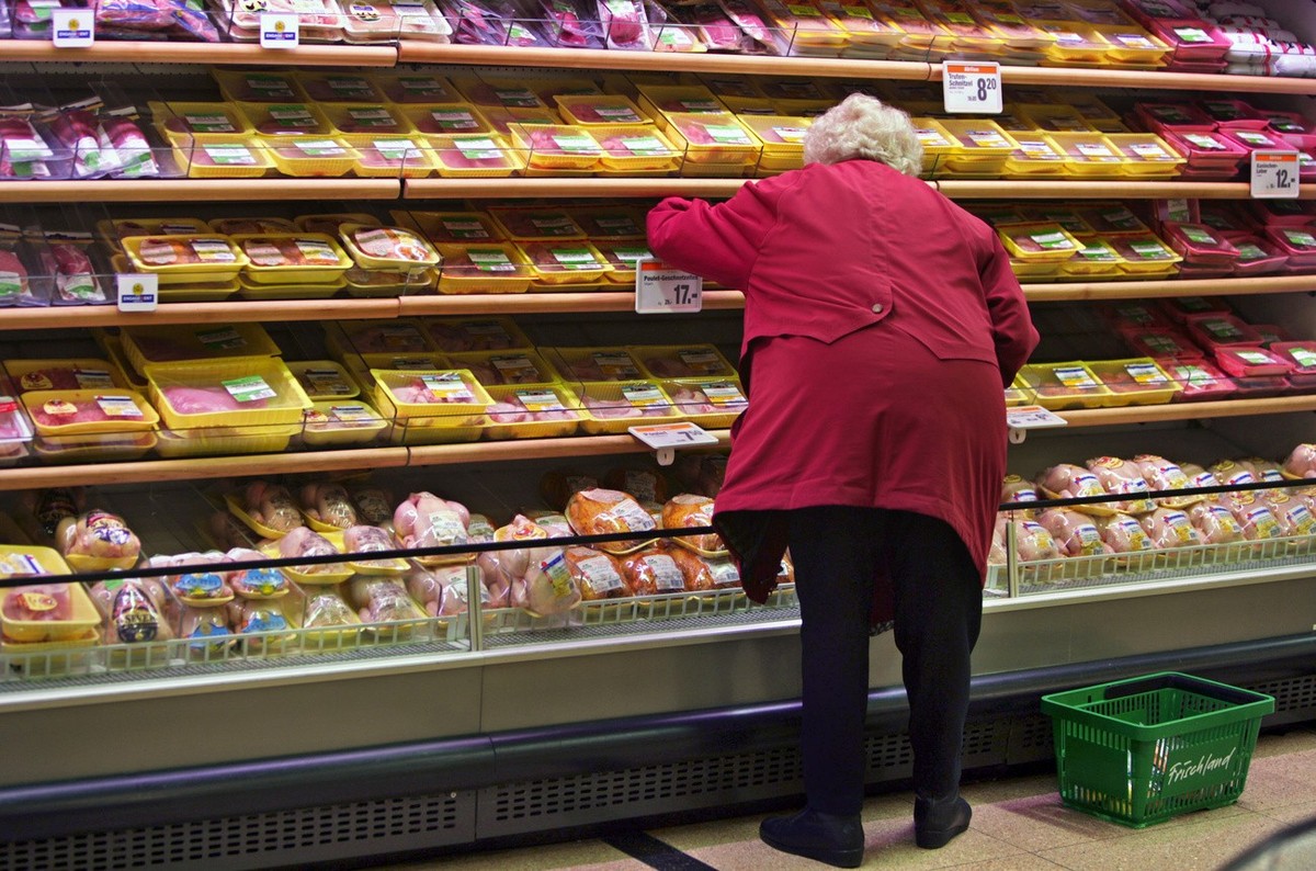 Eine Frau kauft bei einem Regal mit Fleisch am 20. Januar 2005 am 20. Januar 2005 im Migros Limmatplatz in Zuerich ein. Neben ihr steht ein Warenkorb mit der Aufschrift "Frischland". Migros  ...