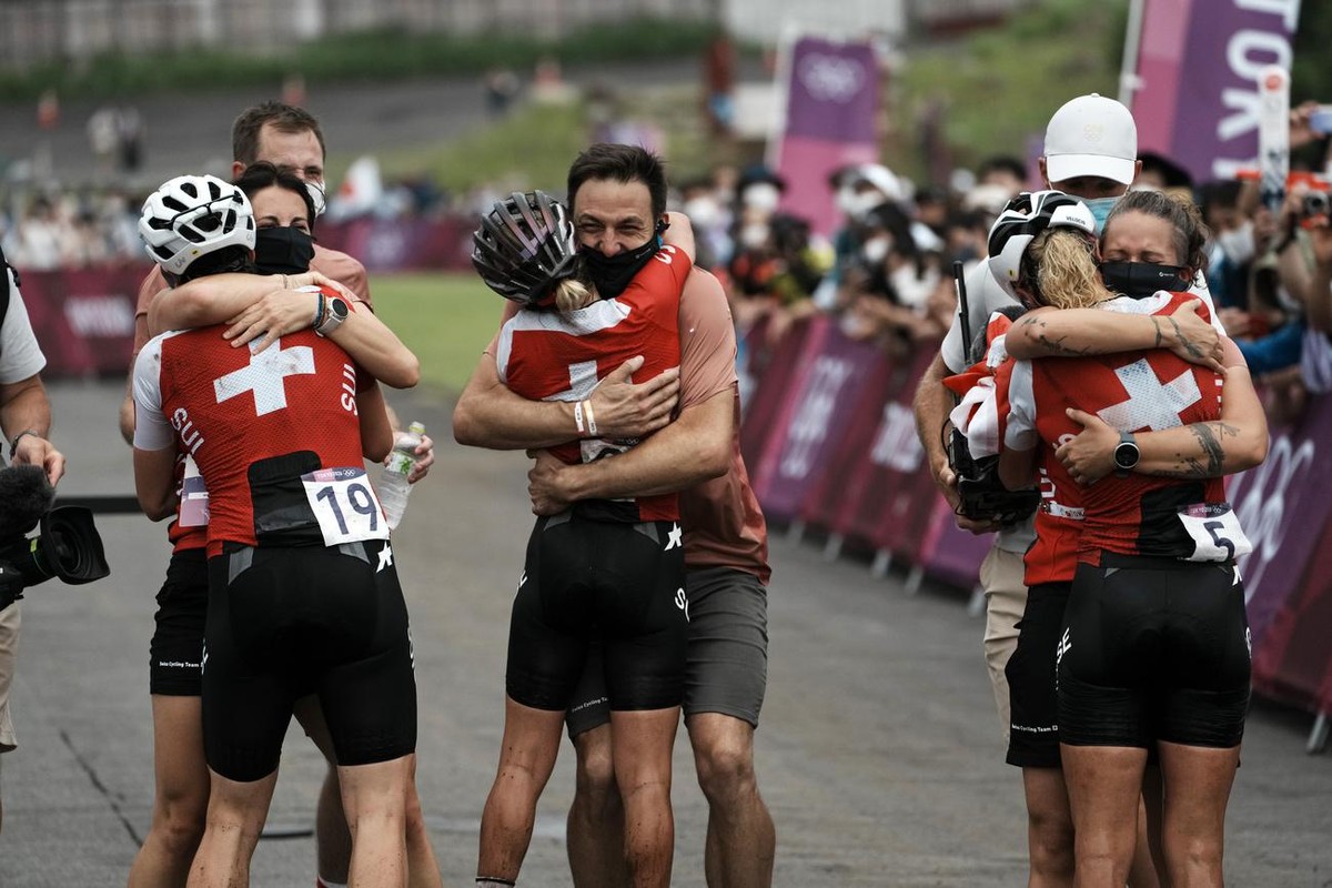 Switzerland's gold medalist Jolanda Neff (5), silver medalist Sina Frei and bronze medalist Linda Indergand (19) are greeted at the finish line after sweeping the podium during the women's c ...