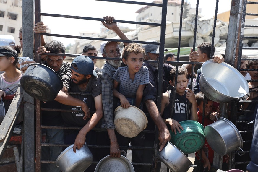 GAZA CITY, GAZA - AUGUST 28: Palestinians, including children, who are struggling to access food due to Israel&#039;s blockade and ongoing attacks on the Gaza Strip, gather to receive hot meals distri ...